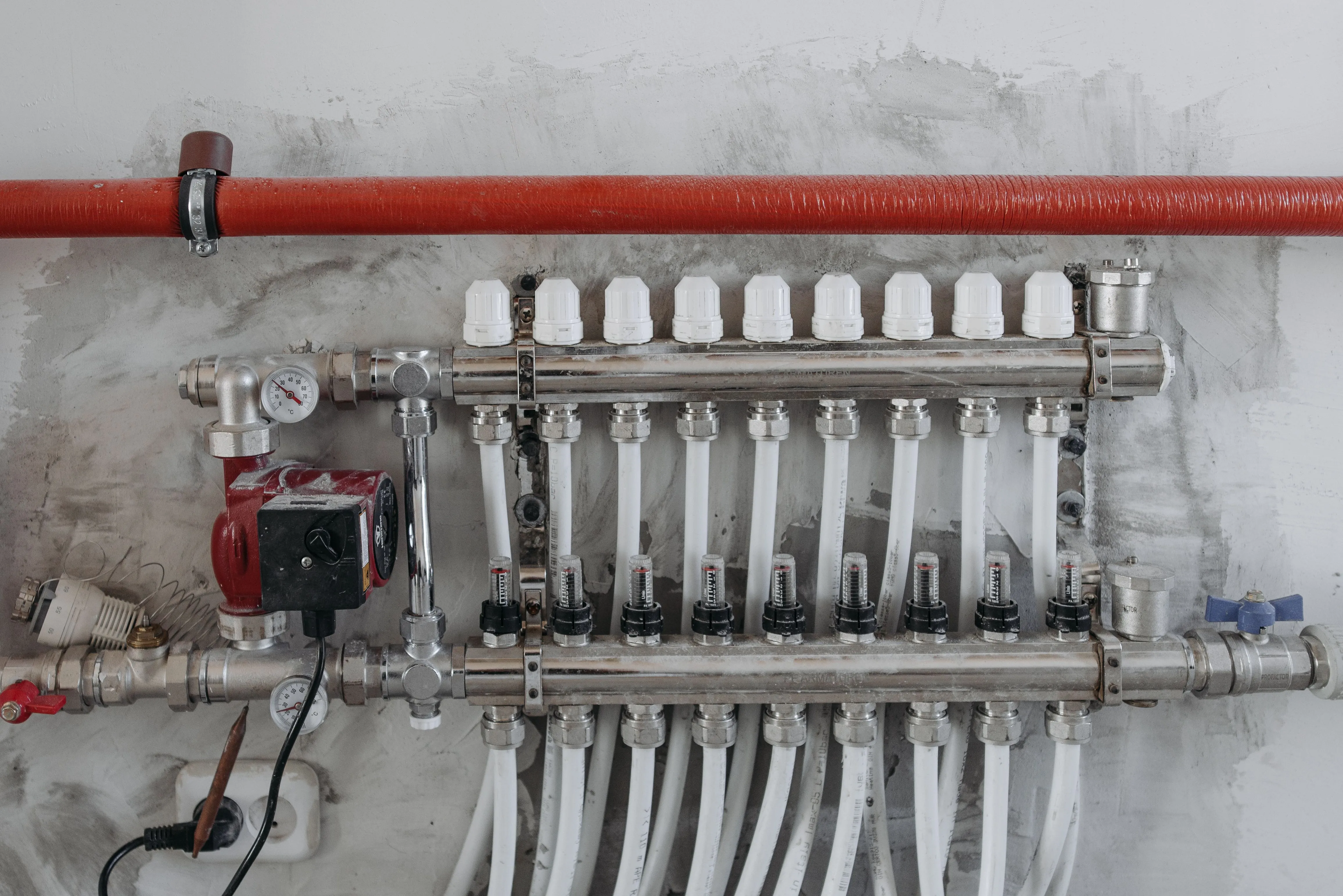 Collecteur de distribution d'eau sanitaire et ses départs, posé au mur.